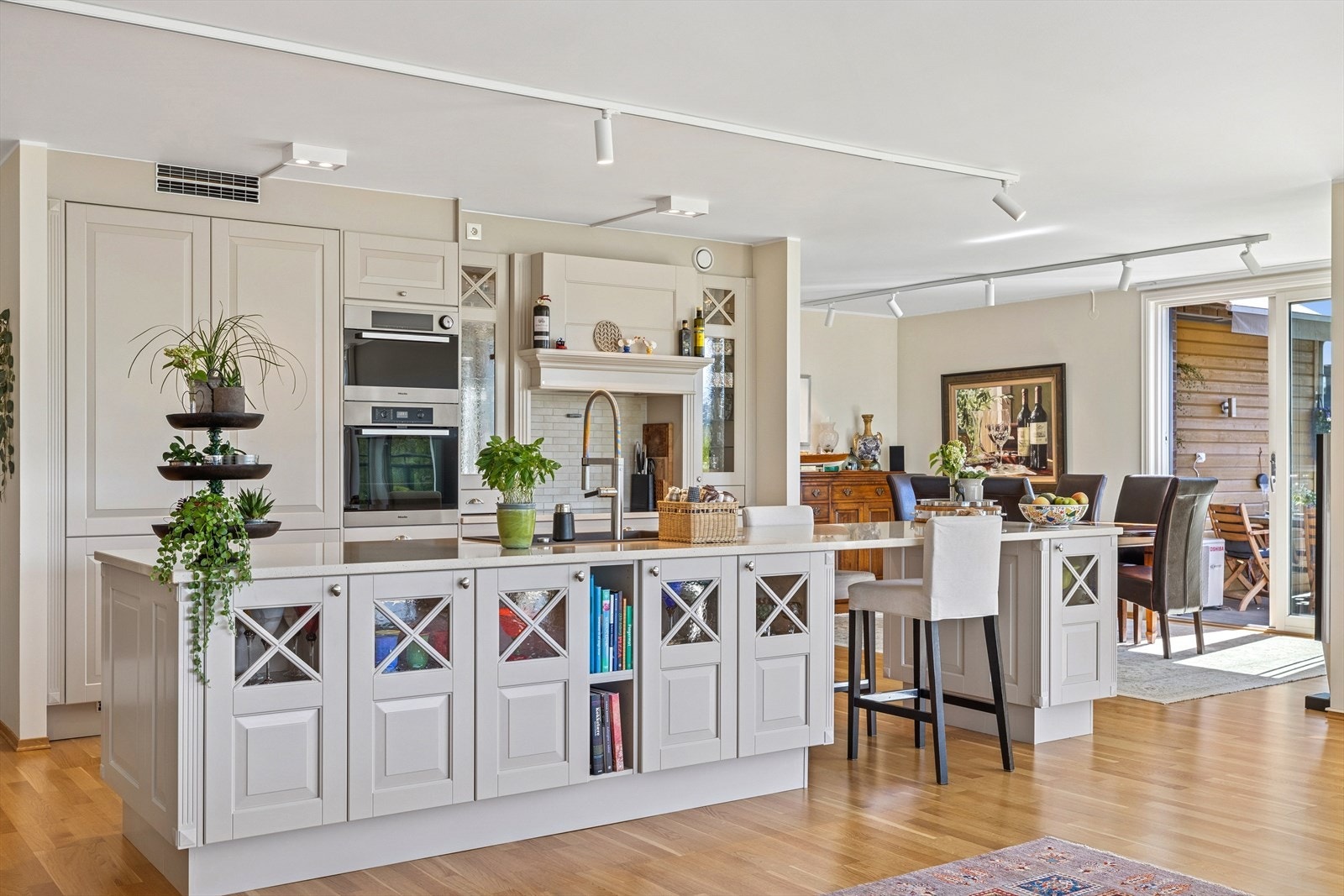 Kjøkkenet har fliser over benk, utslagsvask, kjøkkenventilator og opplegg for oppvaskmaskin. Stedvise overskapsfronter med glass. Komfyrvakt over kokested. Galleribilde