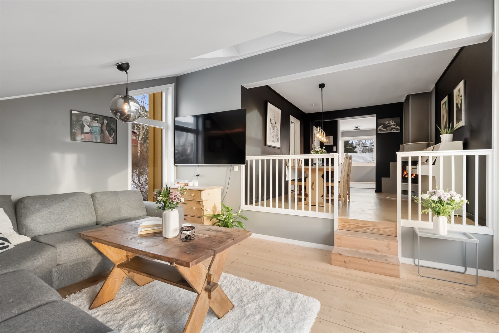 Stuen er et lyst og romslig oppholdsrom med tregulv og flere vinduer. Galleribilde