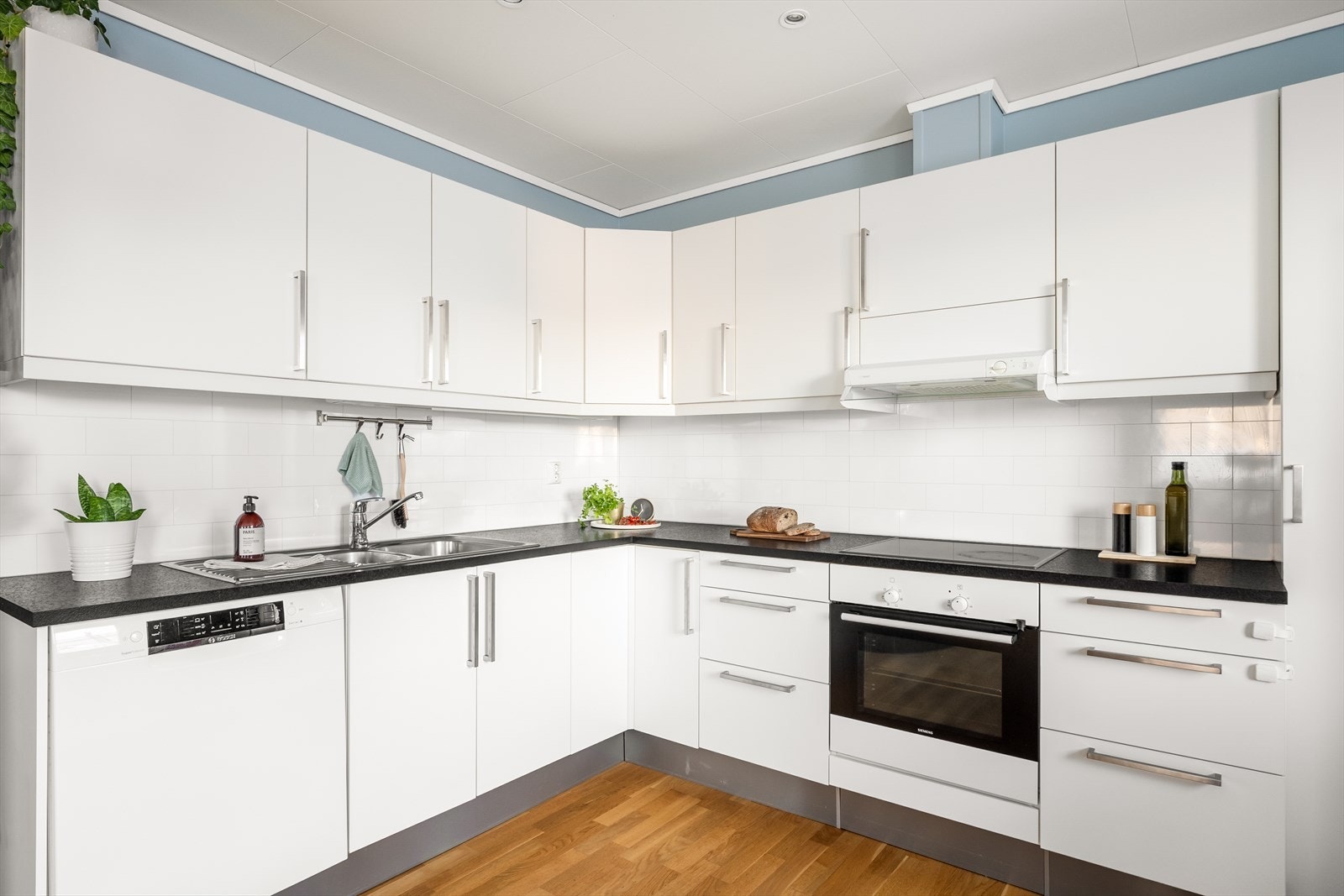 Kjøkkenet har lyse, slette fronter med laminert benkeplate og kitchen board over benk. Galleribilde