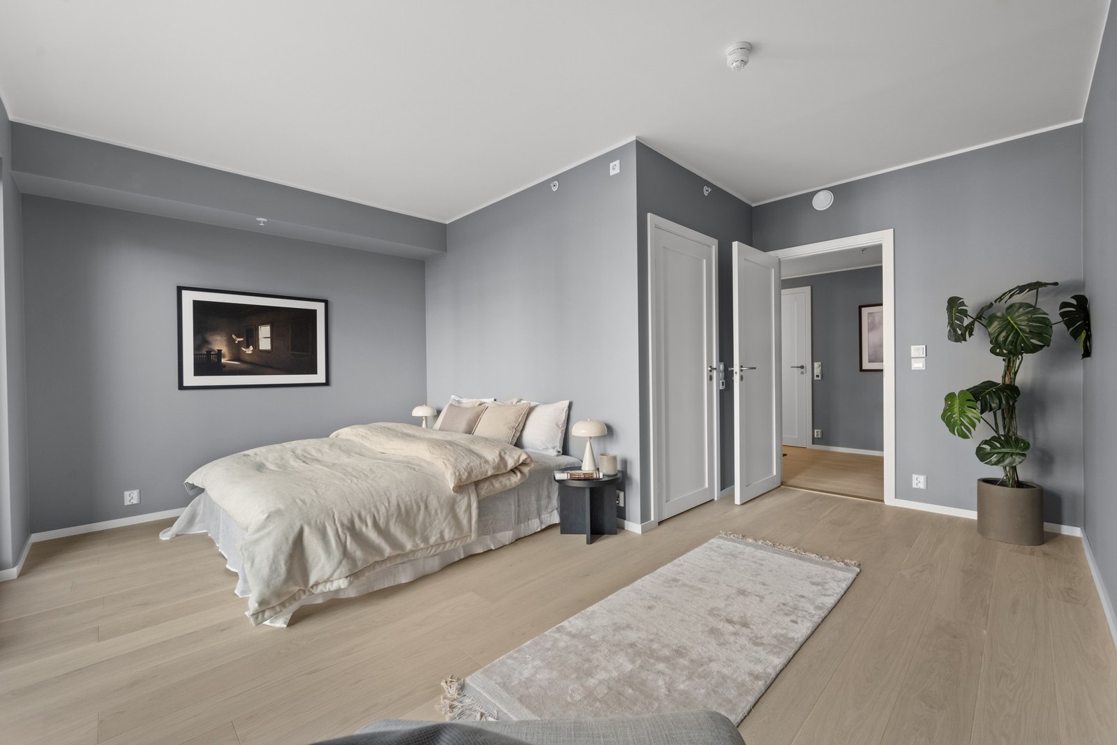 Leiligheten inneholder også to romslige soverom,her fra hovedsoverommet. Her er det god plass til både dobbeltseng med nattbord samt klesoppbevaring. Det er også plass til hjemmekontor om det er behov for det. Galleribilde