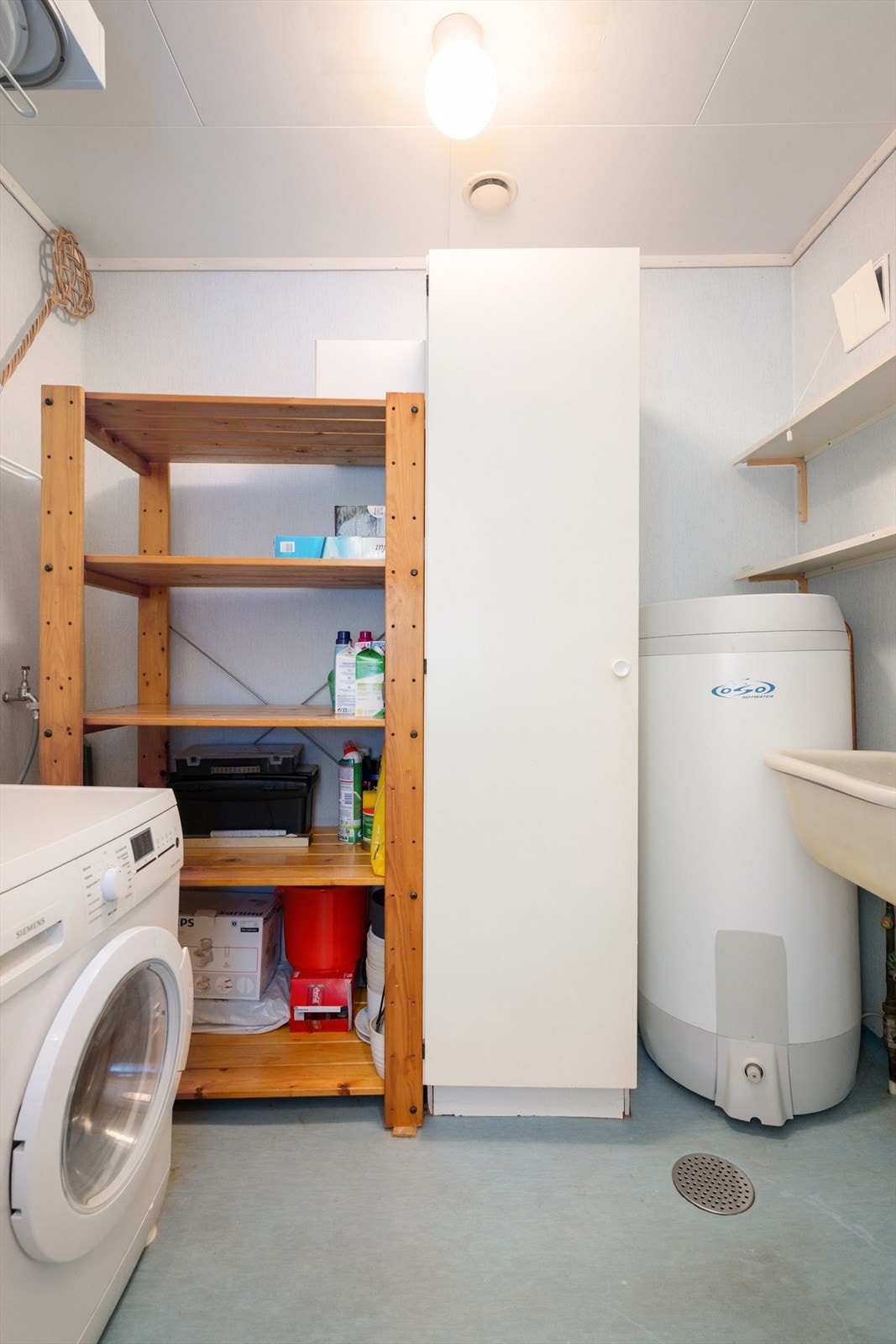 Vaskerommet innehar veggmontert tørkestativ, skyllekar og opplegg for vaskemaskin. Galleribilde