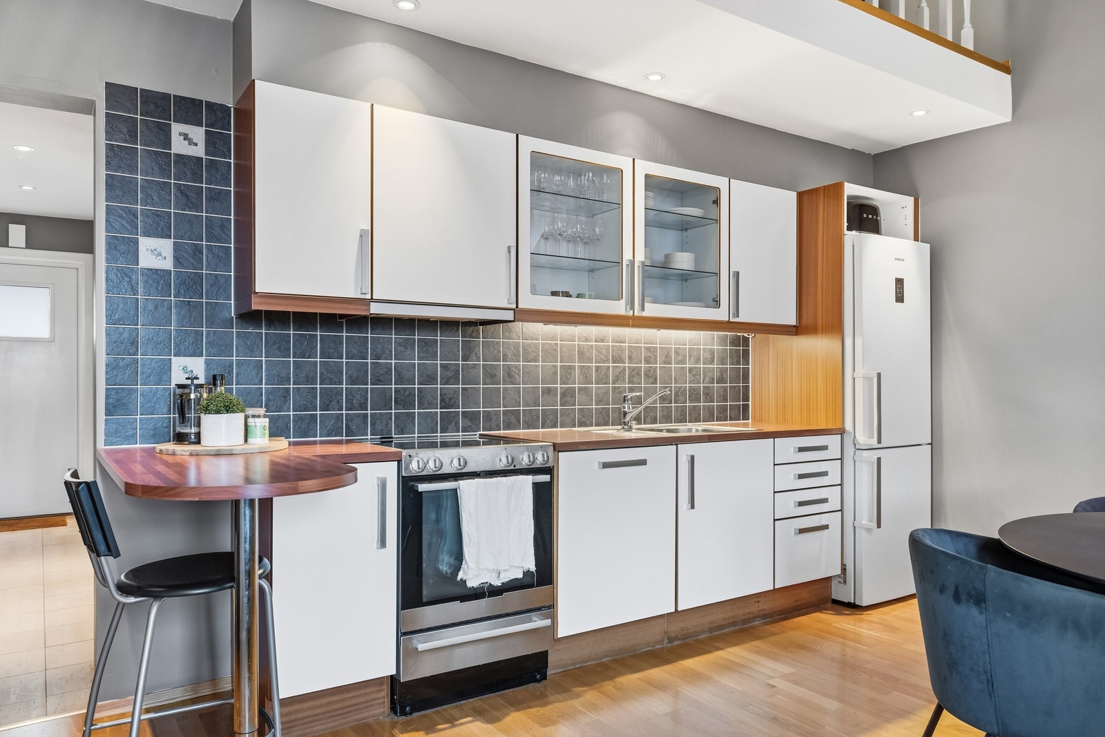 Kjøkken med godt med både skap og benkeplass. Smart løsning med halvøy som gir plass til dagens mindre måltider eller at besøket kan være sosiale ved matlaging. Galleribilde