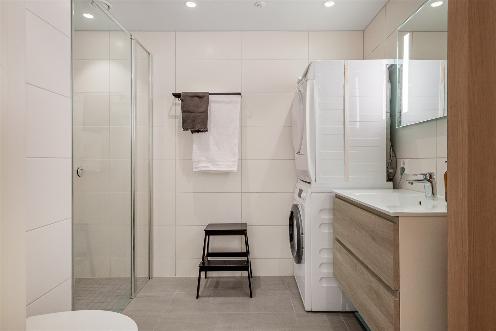 Lyst og delikat baderom med dusjhjørne og praktisk innredning. Galleribilde