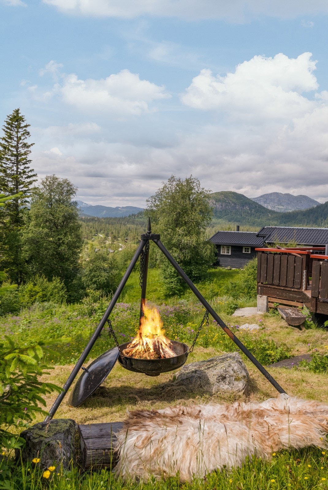 Den luftige tomten består av nydelig naturtomt, og det er etablert både en koselig bålpanneplass samt benk med sitteplasser øverst på tomten. Galleribilde