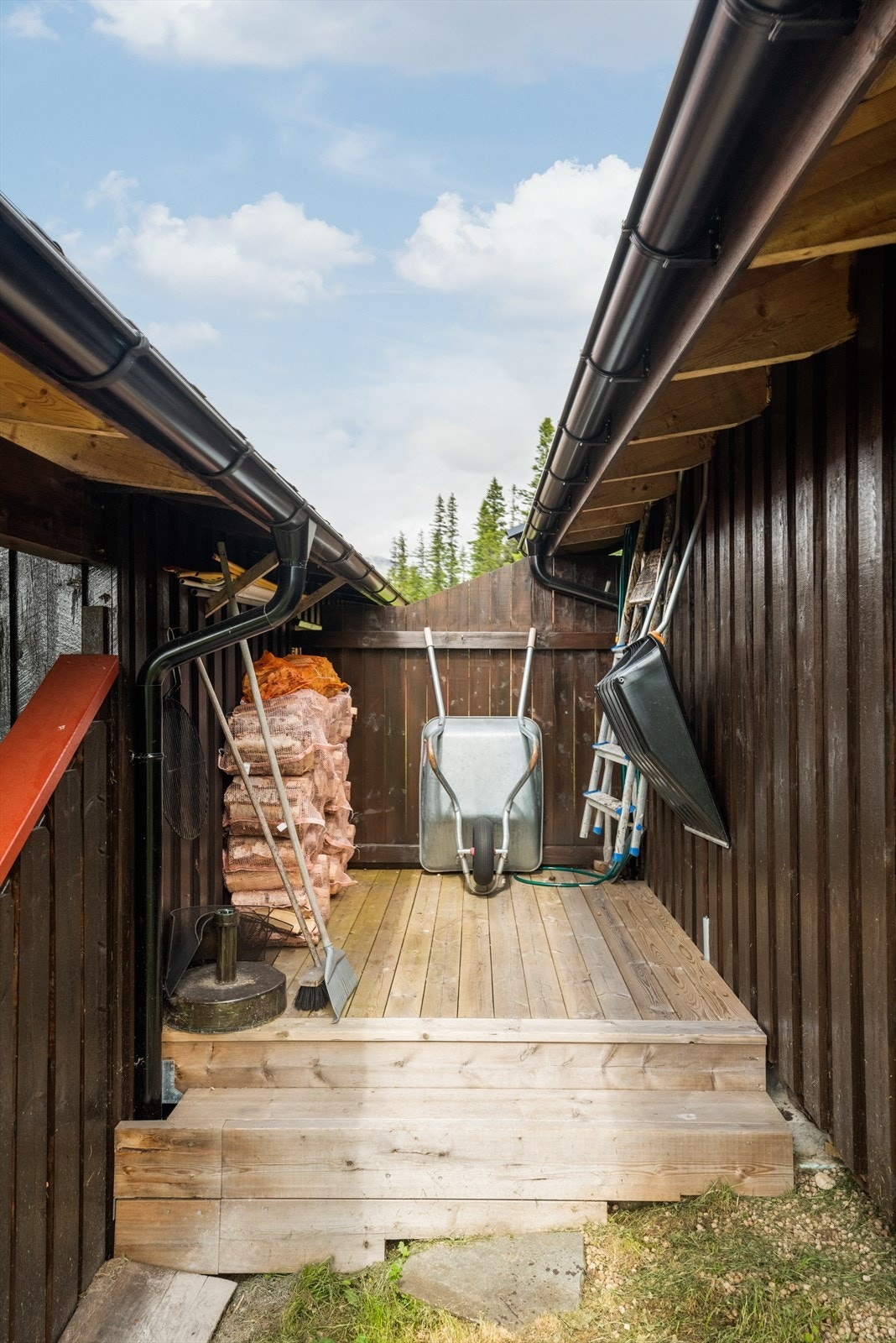 Mellom hytta og annekset er det laget til en praktisk plass hvor ved, redskap og diverse annet kan oppbevares. Galleribilde