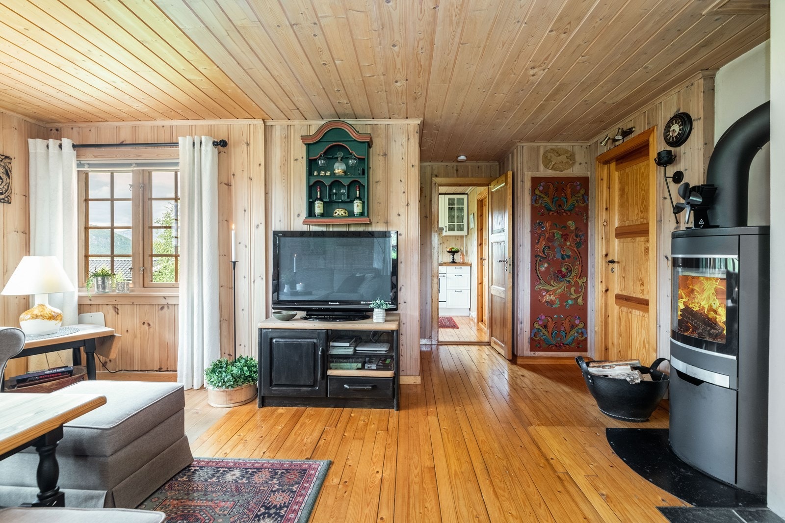 Inntil stua er det etablert en praktisk bodplass med rosemalt dør. Galleribilde