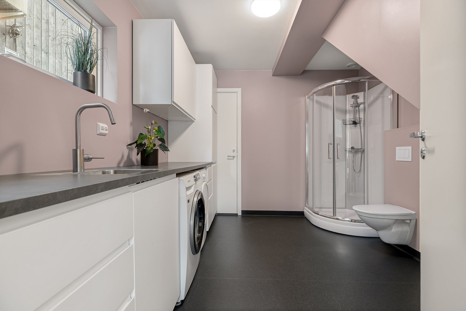 Praktisk vaskerom/baderom med slitesterkt vinylbelegg og varmekabler på gulvet. Opplegg for vaskemaskin er på plass Galleribilde