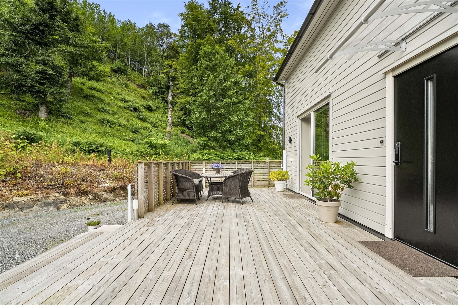 Inngangsparti med terrasse - det er felt mykje skog i Likkjeåsen som gir godt med lys på eigedomen Galleribilde