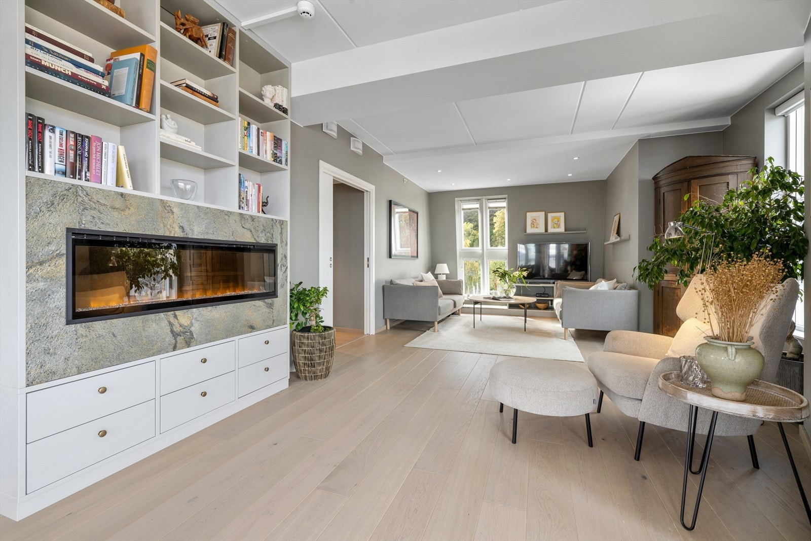 Leiligheten har en innbydende stue med flere møbleringssoner. Galleribilde