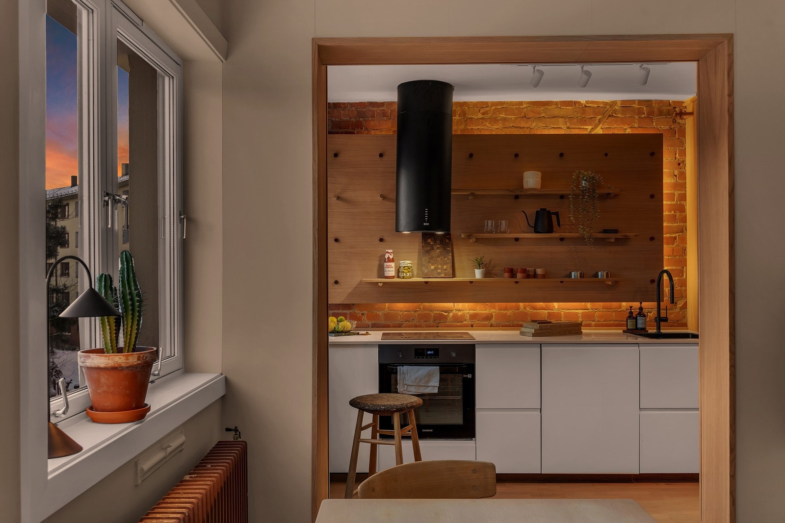 Her får du eksponert teglstein, nytt kjøkken med integrerte hvitevarer og store vindusflater med frodig utsyn og minimalt innsyn. Galleribilde