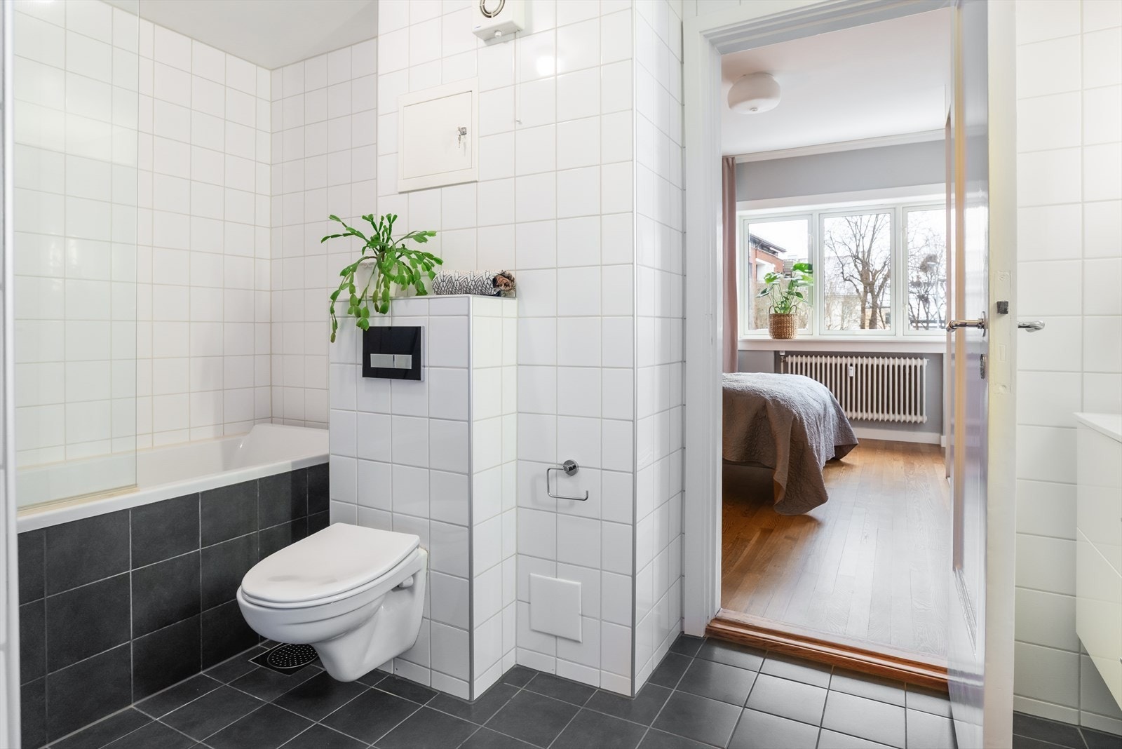 Rommet er utstyrt med innmurt badekar og vegghengt toalett. Det er varmekabler i gulv Galleribilde