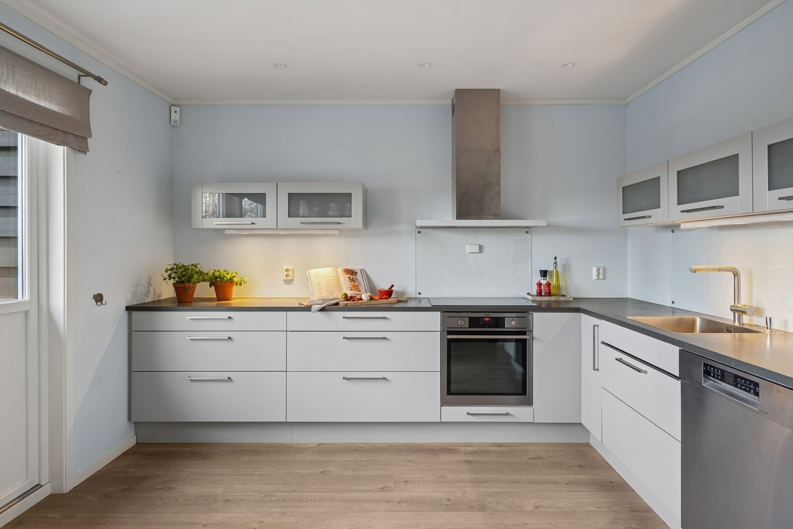 Innredning med laminerte skrog og slette fronter. Det er integrert platetopp, stekeovn og vinskap. Nisjer for oppvaskmaskin og kjøl/fryseskap. Galleribilde