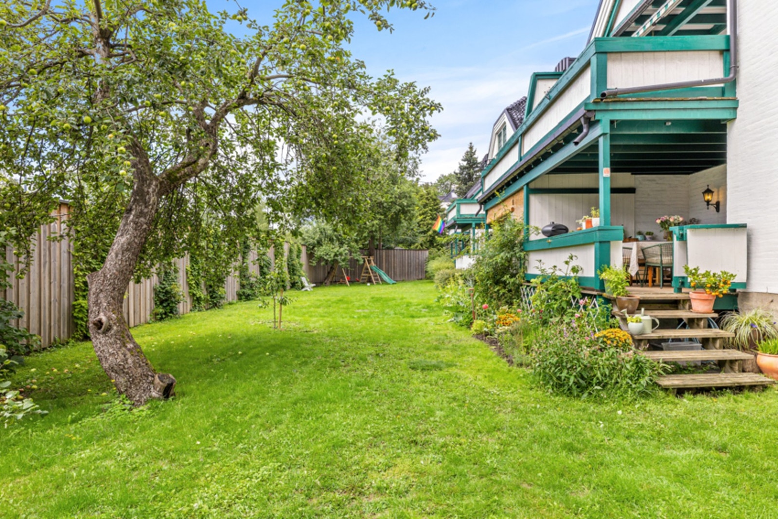 Sameiet har en flotte felles hage med blomsterbed, epletrær og høyt gjerde som sørger for lite innsyn. Galleribilde