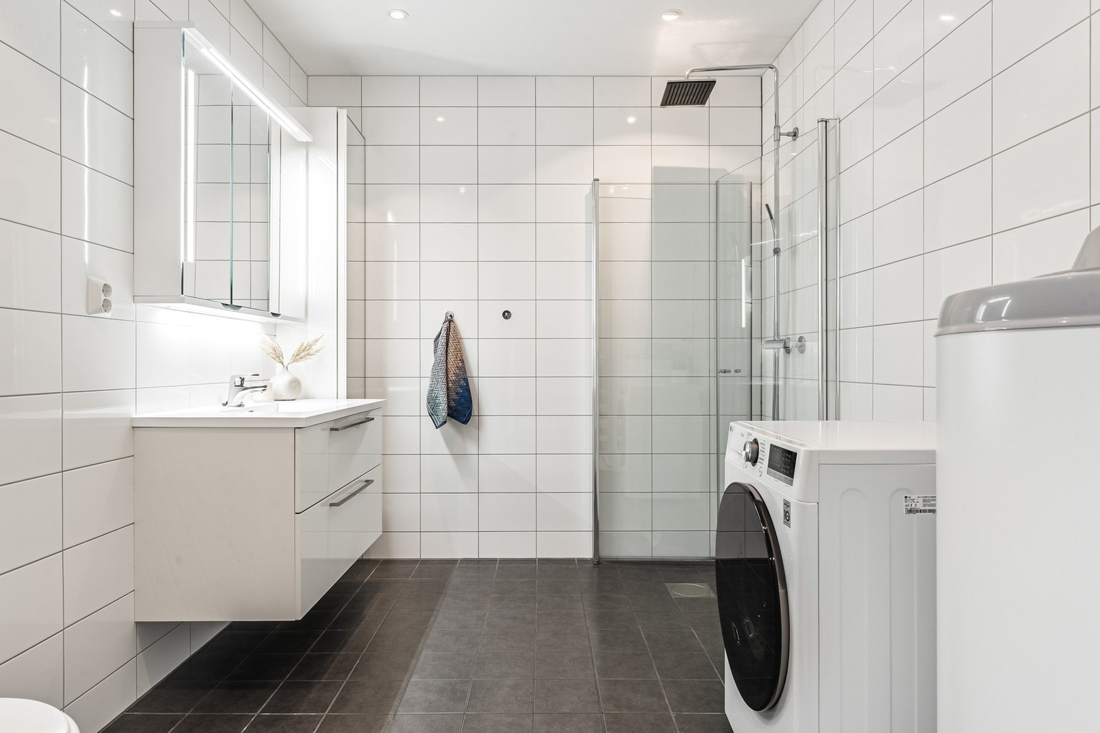 Lyst og helfliset bad på 6,8 kvm med varmekabler i gulv. Galleribilde