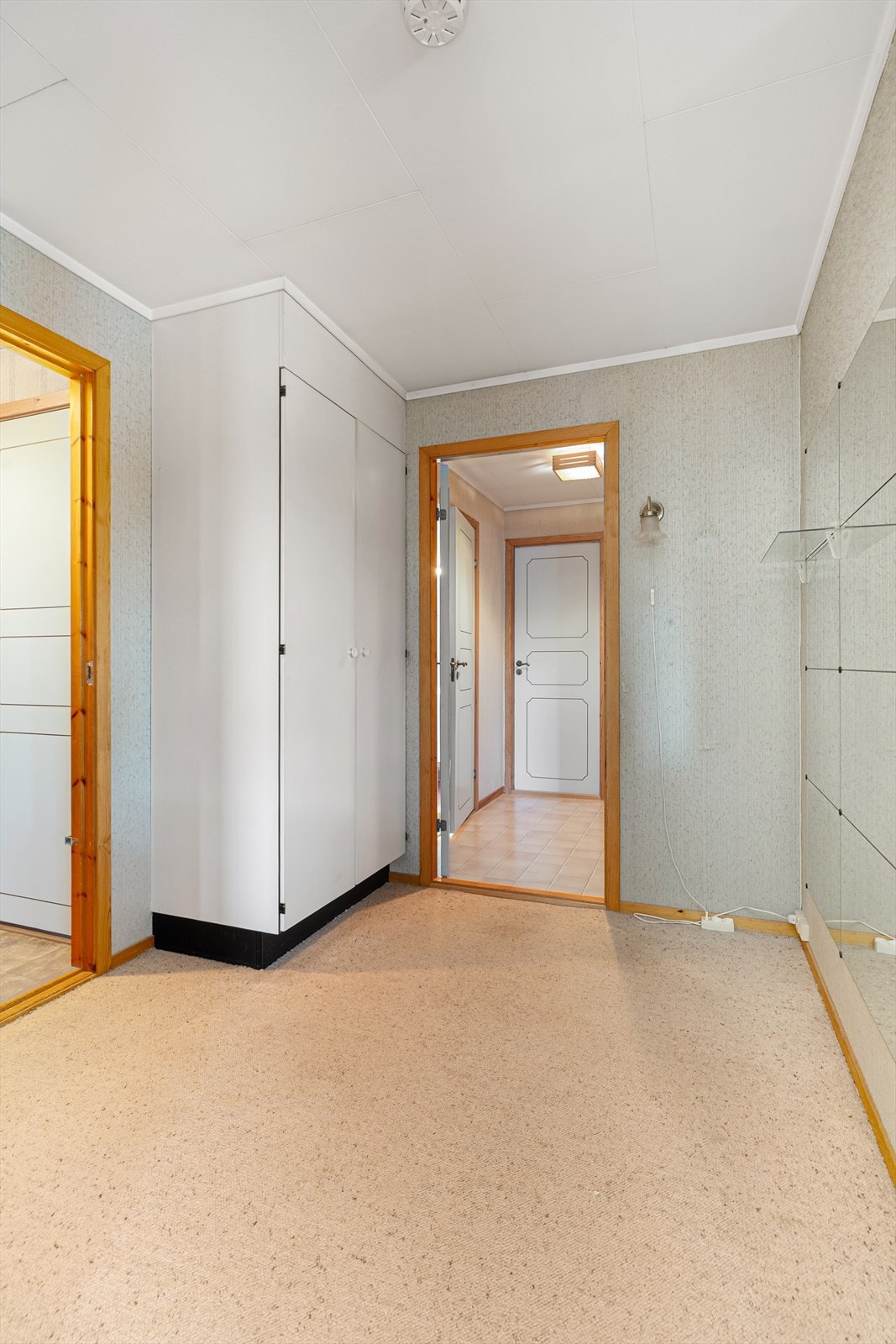 Videre inn er det et romslig gangareal med plassbygget garderobeskap og trapp ned til kjelleretasjen. Galleribilde