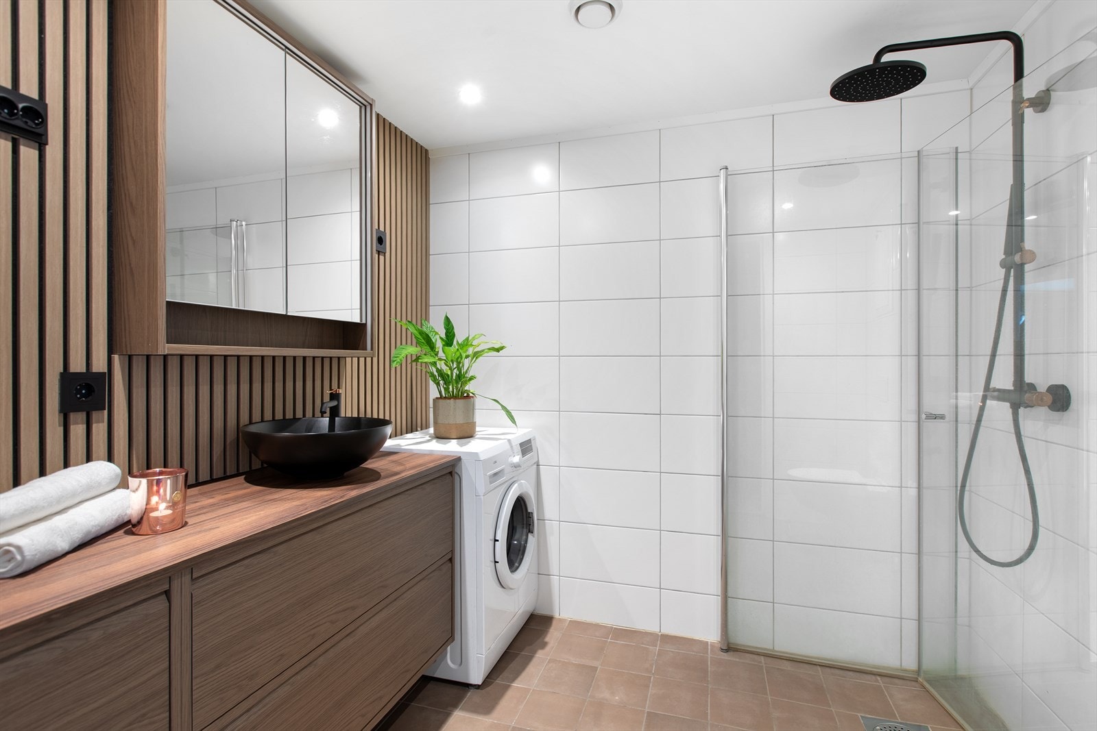 Delikat og tidløs baderomsinnredning. Rommet har innfellbare dusjdører, vegghengt toalett samt opplegg for vaskemaskin og tørketrommel. Galleribilde