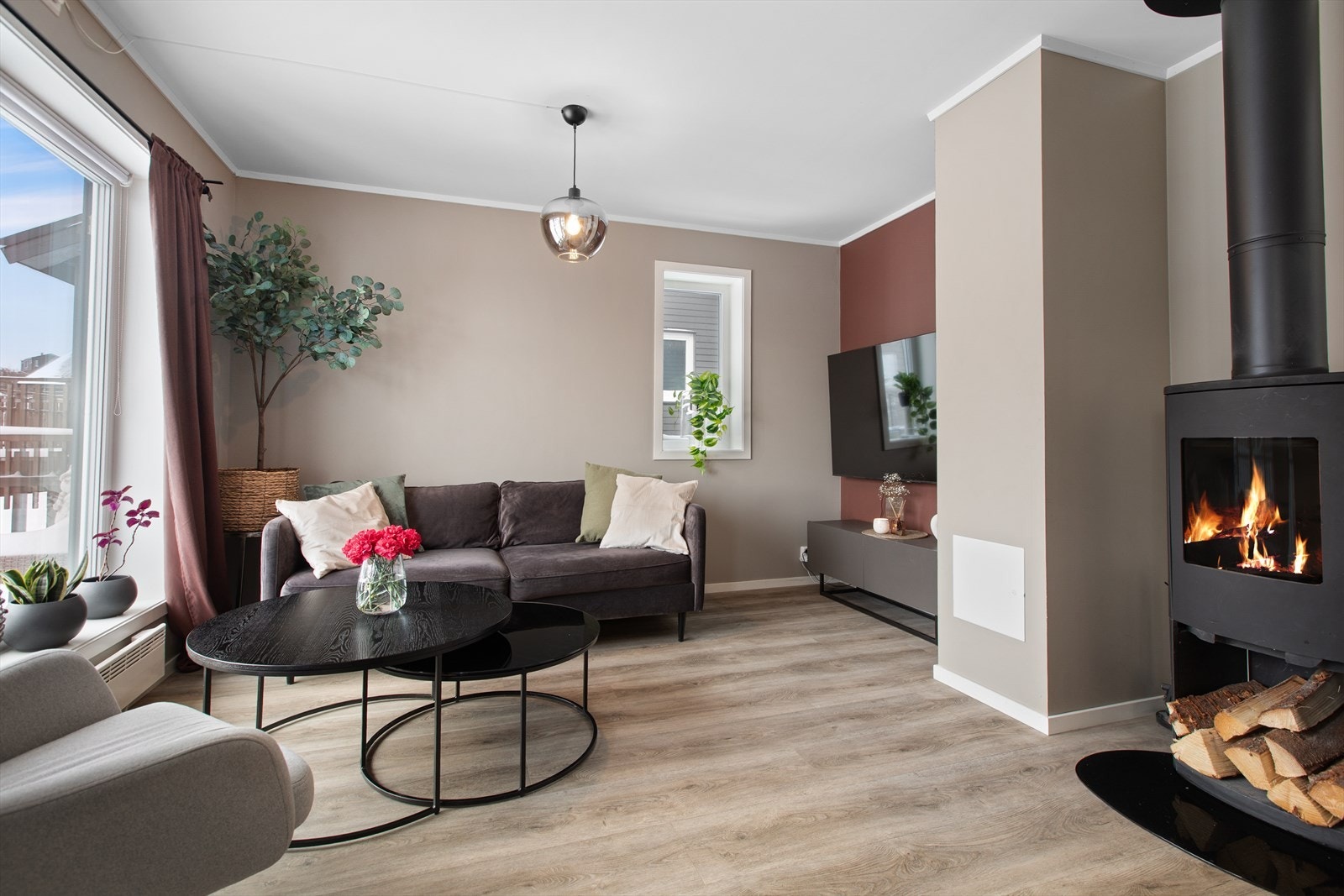 Leiligheten har en koselig TV-krok med flere møbleringsmuligheter. Her kan du slappe av foran TV-en med peiskos. Galleribilde