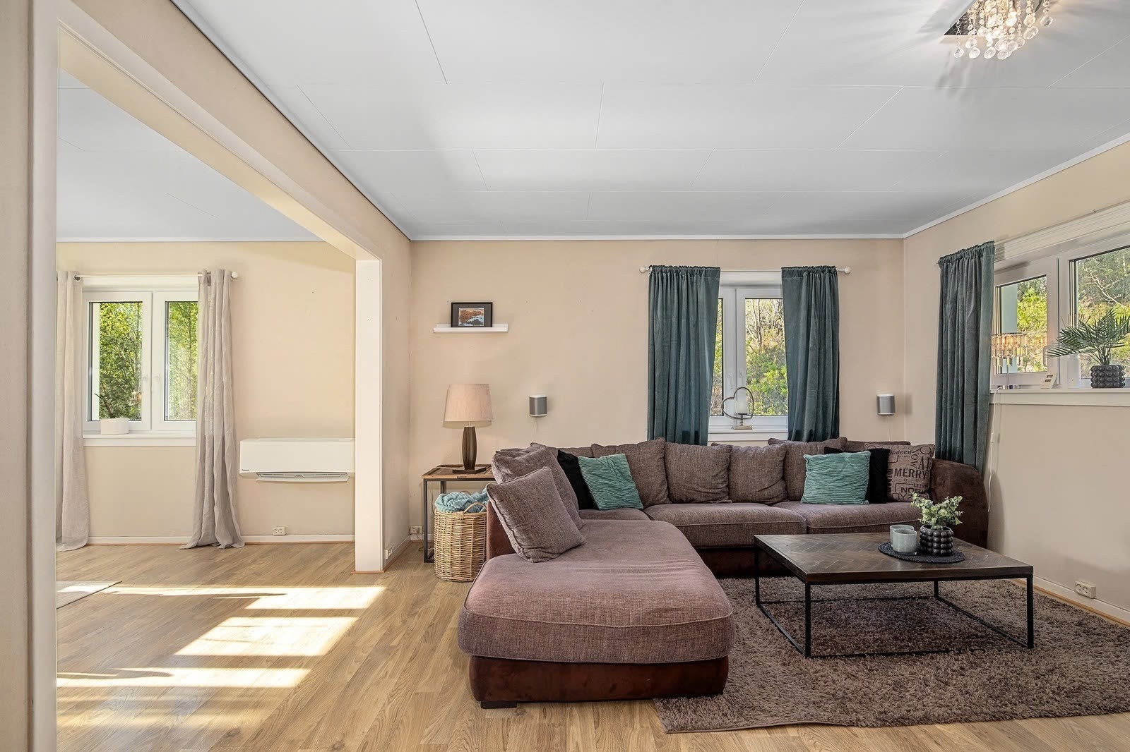 Stor todelt stue med mange viduer som gir godt med lys og en god romfølelse. Galleribilde