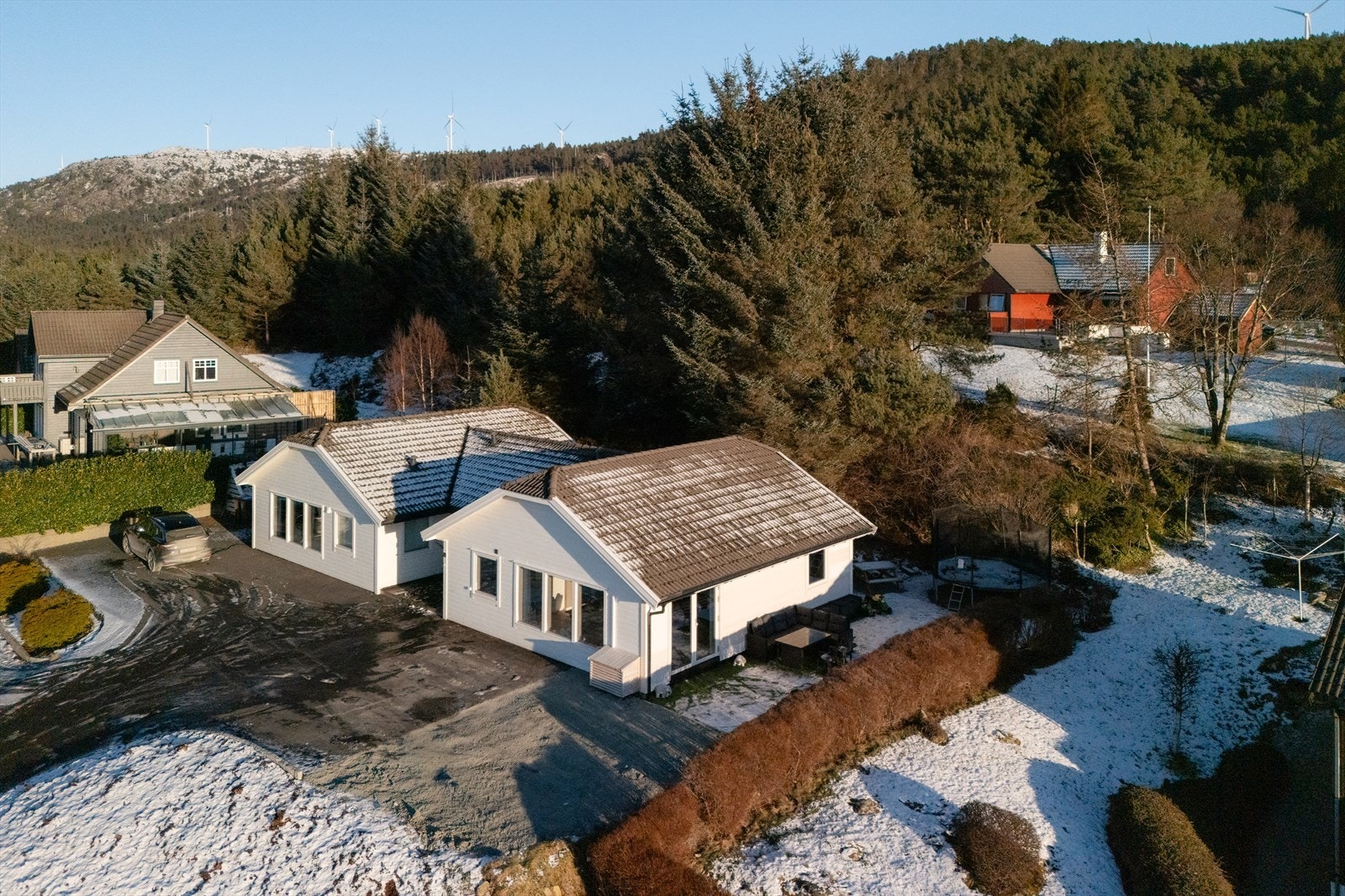 Tomten er pent opparbeidet med beplantning og asfalt fra september 2025. Galleribilde