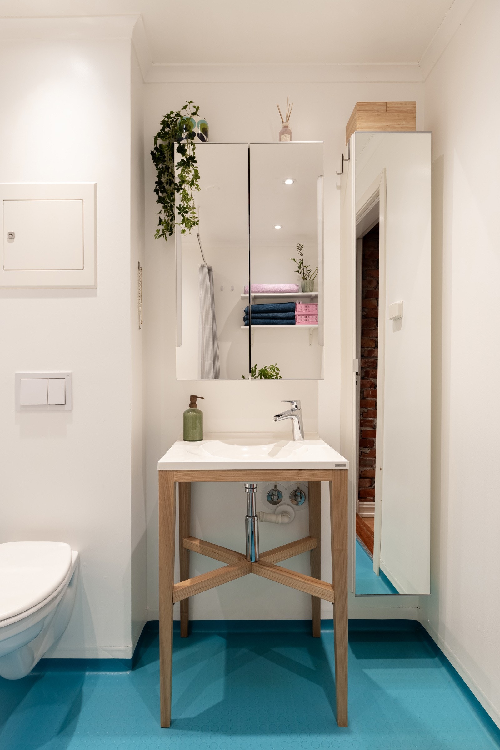 Rommet har gulvstående servant med ett-greps armatur, speilskap, vegghengt speilskap, badekar og vegghengt toalett. Galleribilde