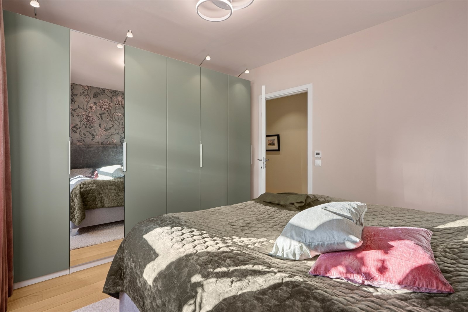 På det ene soverommet finner du en stilfull fondvegg som gir en fin kontrast og harmonerer med garderobens fargetone Galleribilde