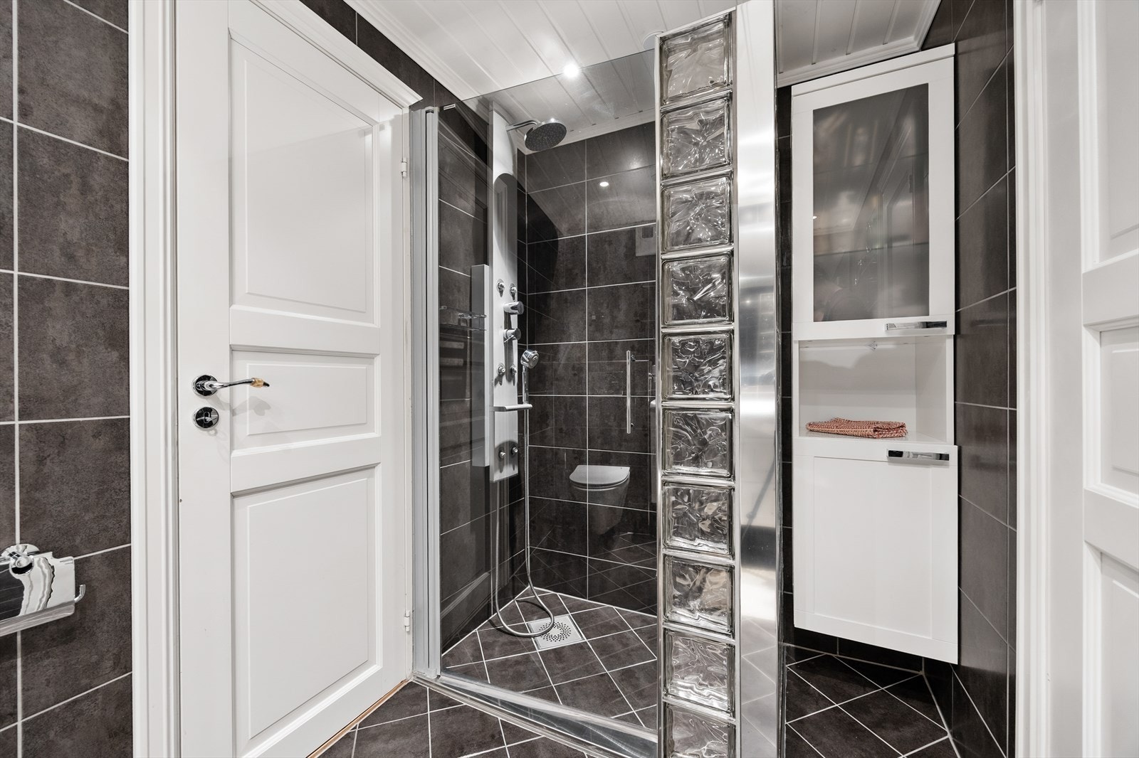 Her er det dusj på gulv med dør i herdet glass, og rommet har mekanisk avtrekk. Galleribilde