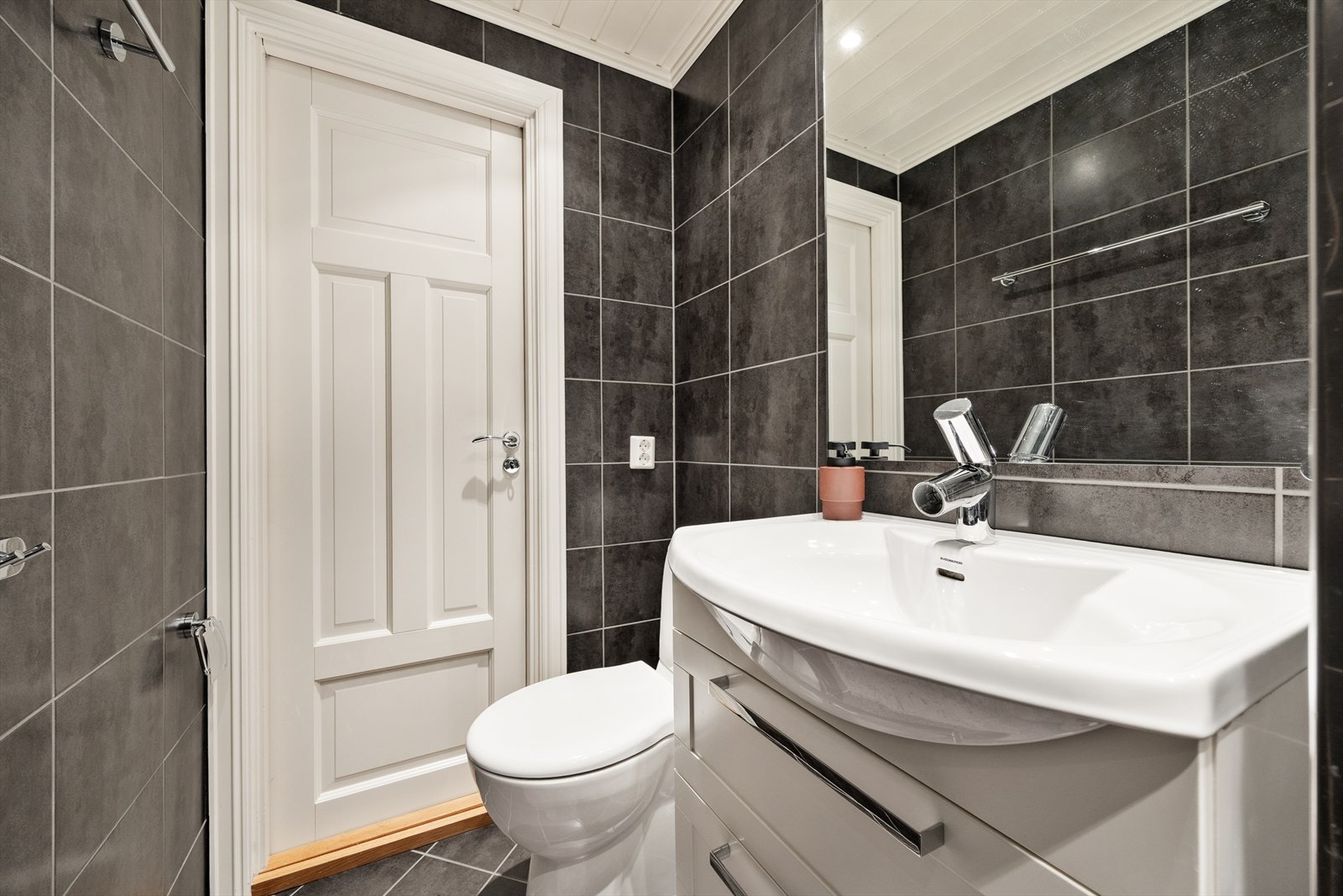 Badet er utstyrt med servantinnredning, klosett, dusj og har varmekabler i gulvet. Galleribilde