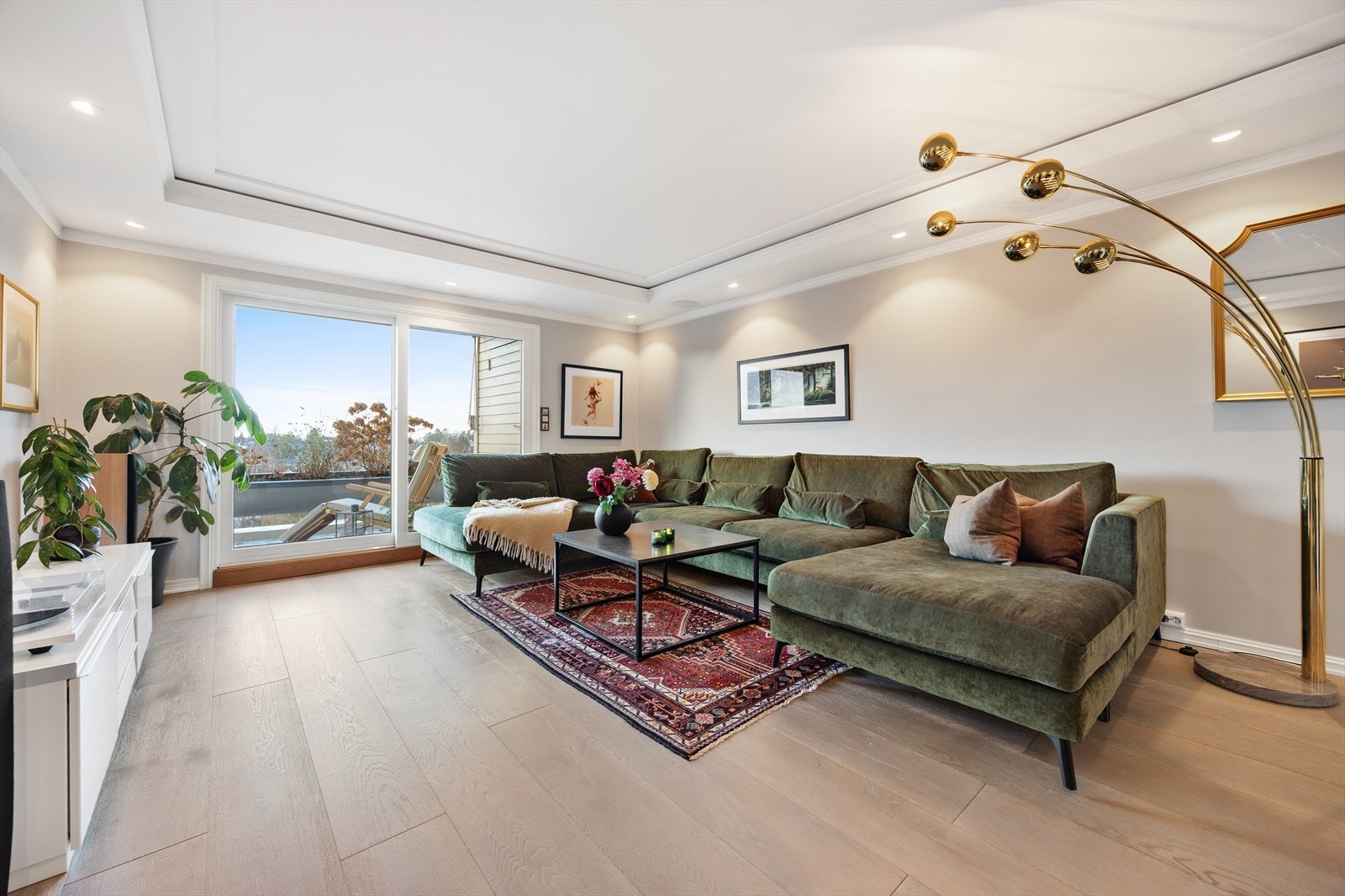 Store vindusflater og balkongdør fra 2015 gir rikelig med naturlig lys inn i stuen. Galleribilde