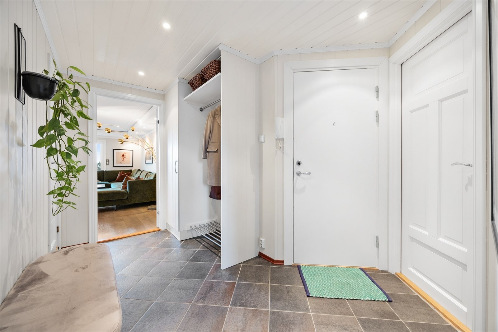 Leiligheten har en innbydende entré med flislagt gulv og varmekabler for økt komfort. Galleribilde