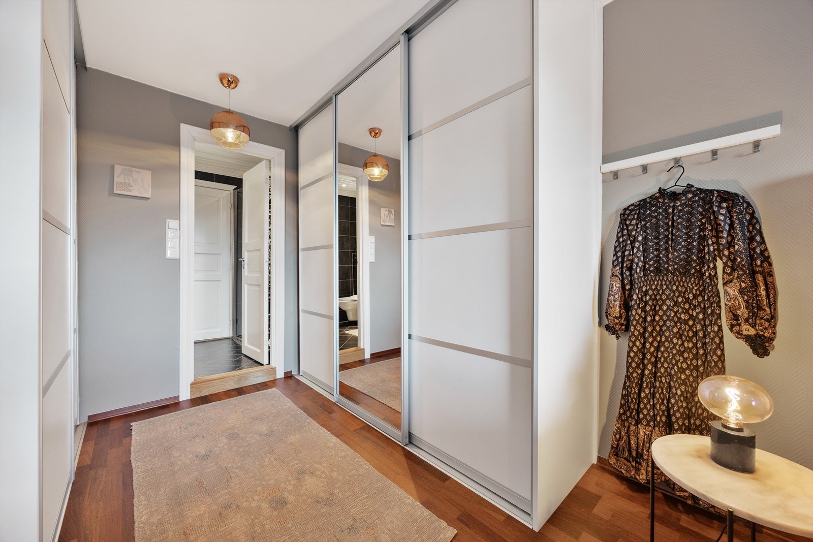 En romslig skyvedørsgarderobe med speilfronter gir rikelig med oppbevaringsplass. Galleribilde