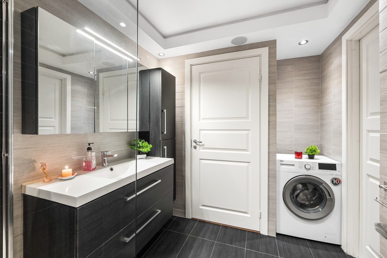 Badet har også godt med oppbevaringsplass, og praktisk nisje for plassering av vaskemaskin bak døren. Vaskemaskinen vil følge med boligen. Galleribilde