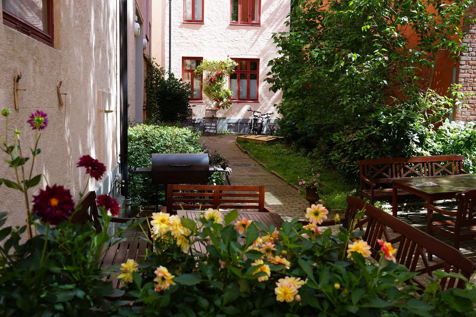 Bakgården har flott beplantning, sittegrupper, grill, kjøkkenhage, sandkasse og sykkelstativ. (Selgers eget bilde). Galleribilde