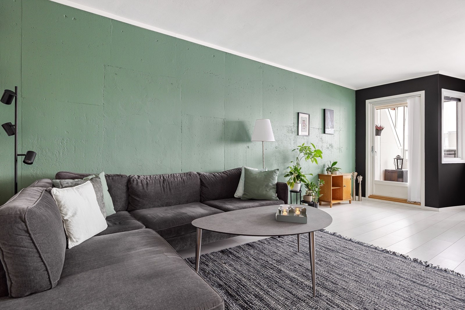 Leiligheten har et særegent uttrykk med malt betongvegg i stua. Galleribilde