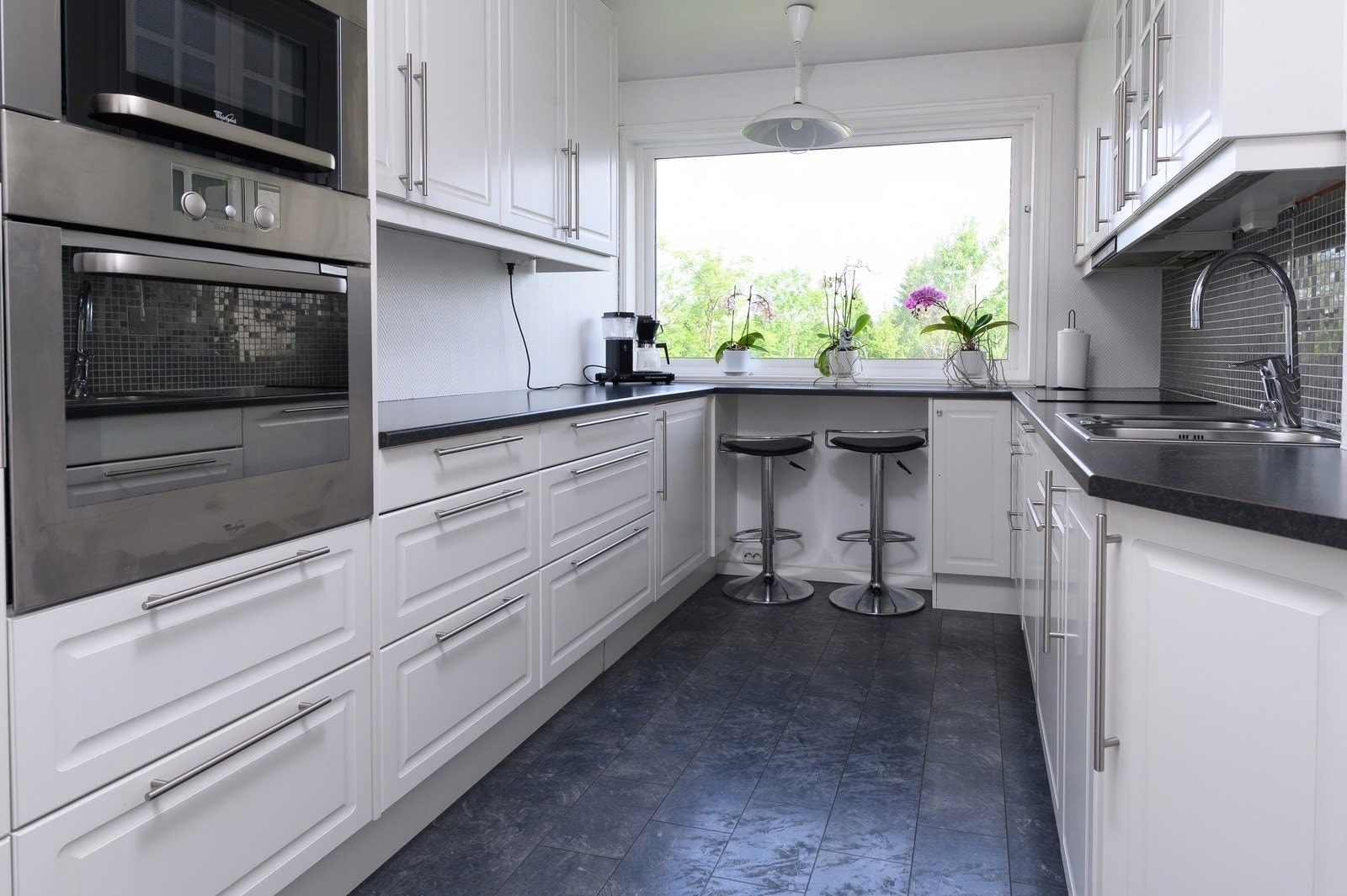 Kjøkken har kjøleskap med frys, oppvaskmaskin, komfyr og vask. Galleribilde