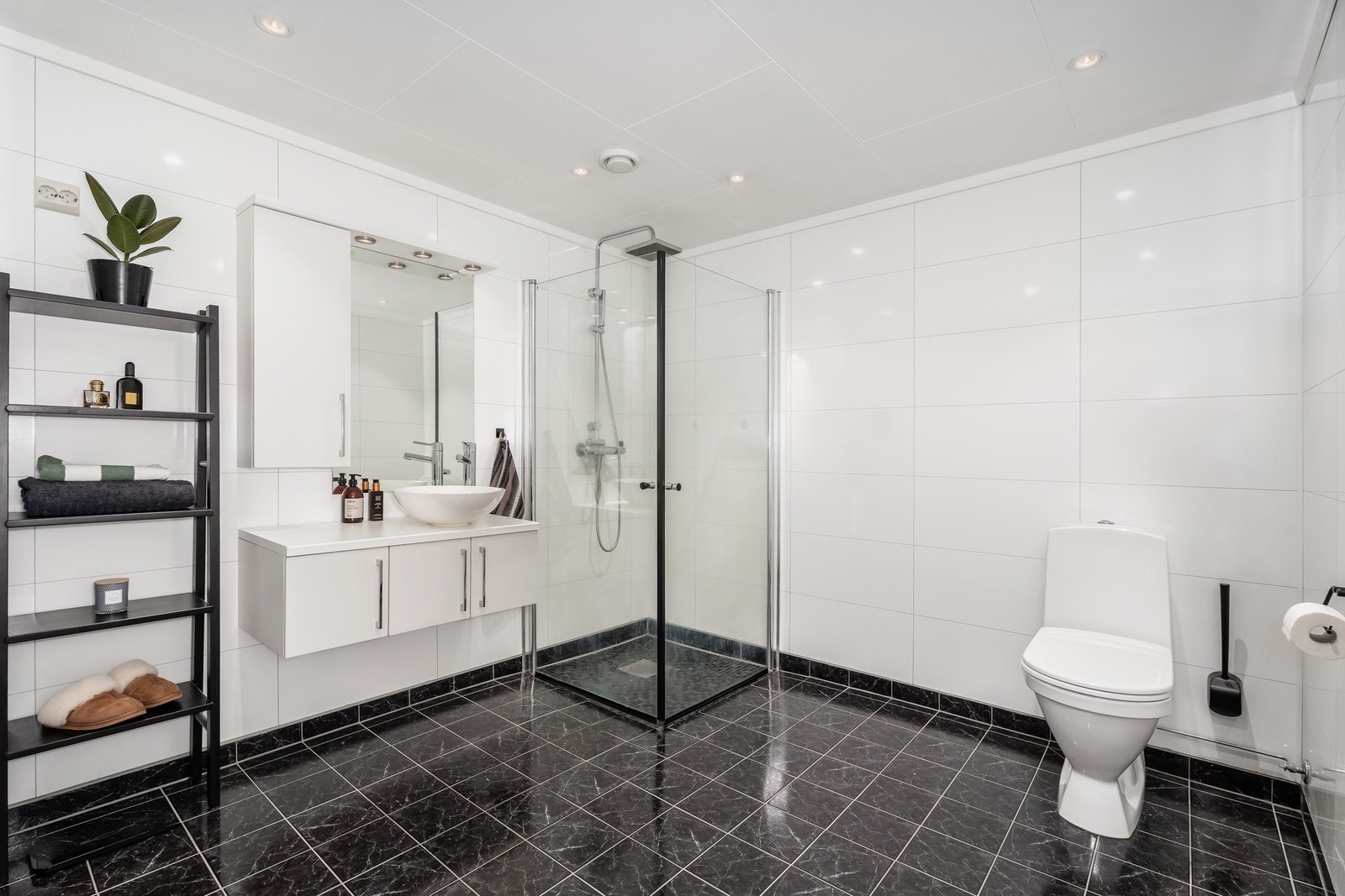 Lyst og flott bad av god størrelse. Badet har våtromsplater (ny 2020) på vegg og fliser med elektriske varmekabler på gulv. Praktisk vegghengt innredning med belysning og dusjhjørne med glassdører Galleribilde