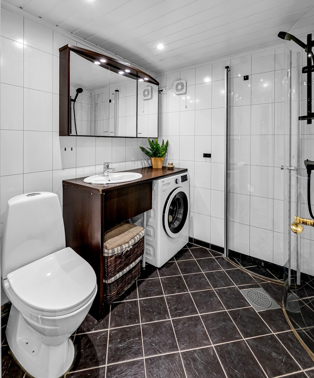 Flislagt baderom med dusjhjørne og opplegg for vaskemaskin. Galleribilde