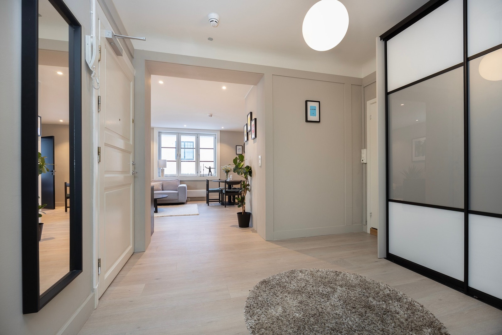 Leilighetens entré er romslig og tilbyr rikelig plass til oppbevaring av yttertøy i skyvedørsgarderobe. Galleribilde