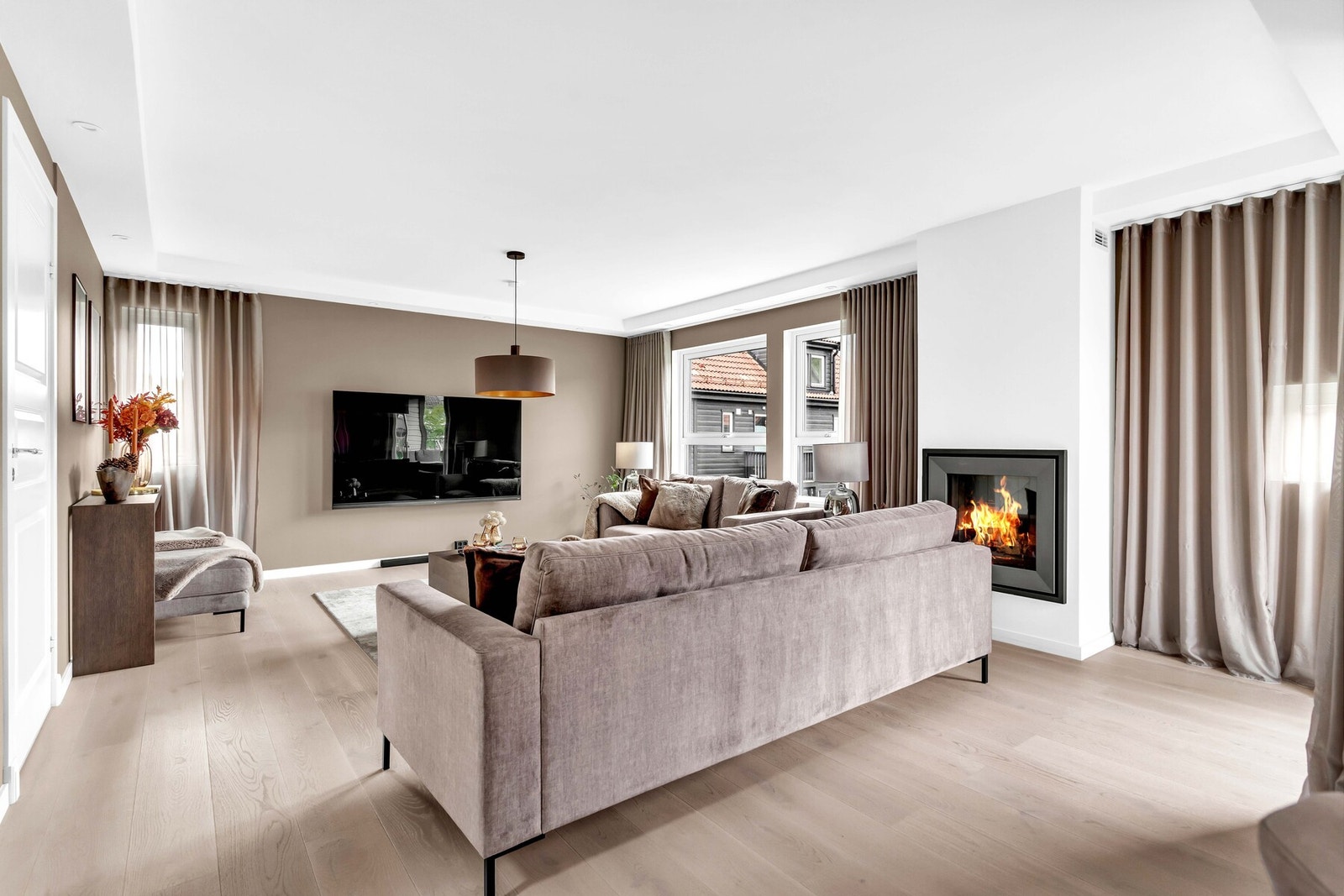 De store vindusflatene gir både rikelig lys og et hyggelig utsyn mot nærområdet, samtidig som gardinene gir en eksklusiv følelse. Galleribilde