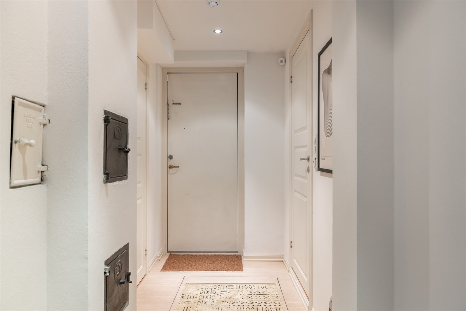 Lys gang mellom rommene i u.etg. Utgang til felles kjellerareal samt til to av totalt fire boder som tilhører boligen. Galleribilde