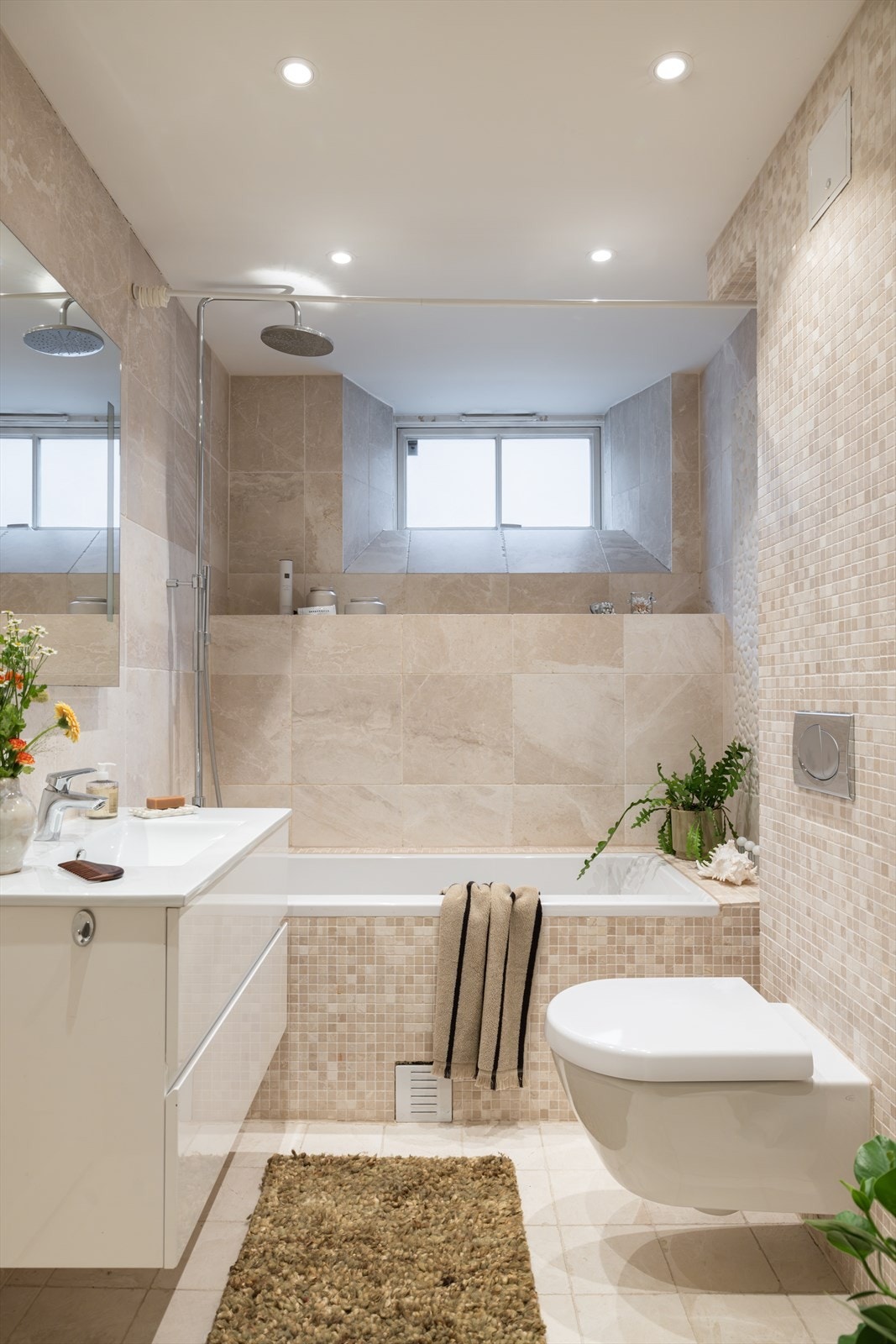 Badet inneholder servant med oppbevaring i skuffer, vegghengt speil med lys, Willeroy Boch badekar og toalett. Galleribilde