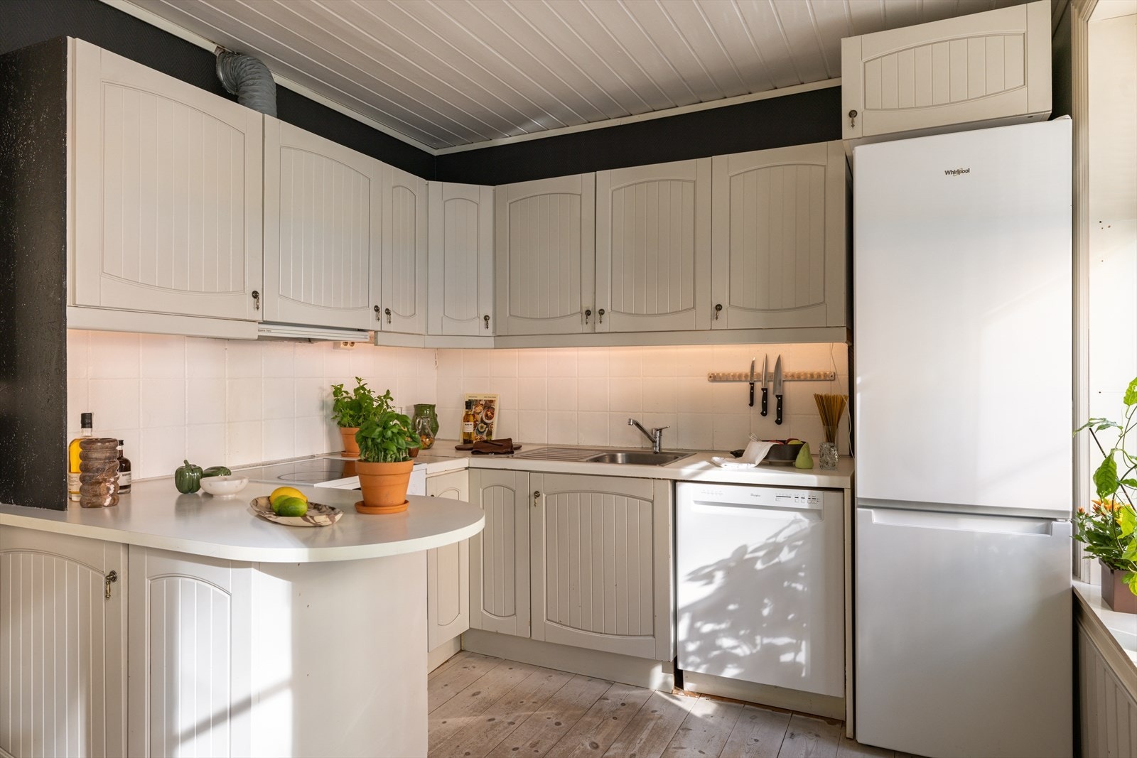 Kjøkkenet er tilbaketrukket i eget hjørne. Her med god oppbevaring- og benkeplass. Kjøkkenet er eldre men fullt funksjonelt. Galleribilde