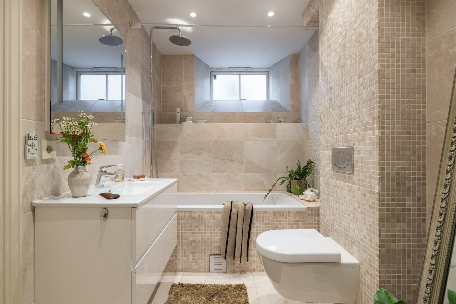 Lekkert flislagt baderom fra 2010. Det er flislagt med marmorfliser og oppleves som tidløst og moderne. Galleribilde