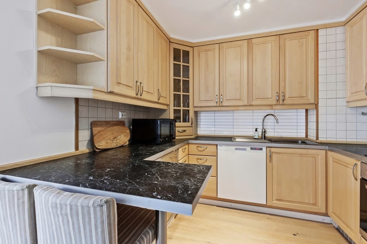 Pent og klassisk kjøkkeninnredning med nye skap- og benkeplass. Galleribilde