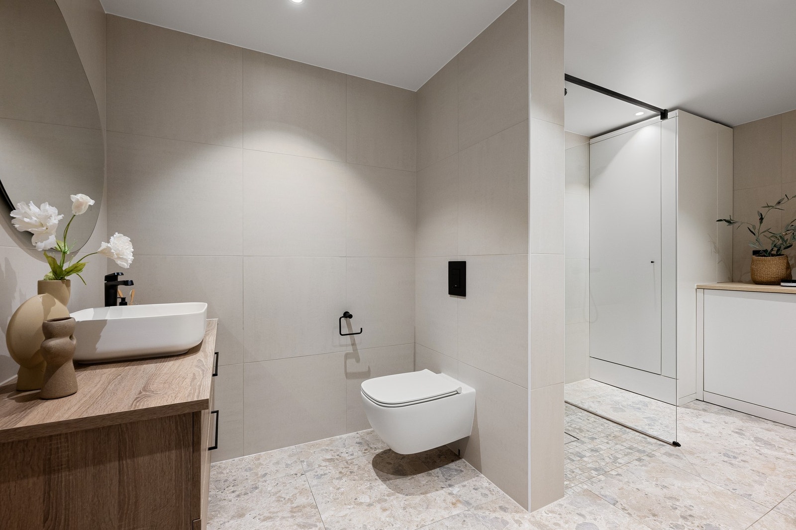 Stort og moderne baderom fra 2024 med gjennomført flisvalg, gulvvarme og et stilrent uttrykk - utført av faglærte med dokumentasjon. Galleribilde