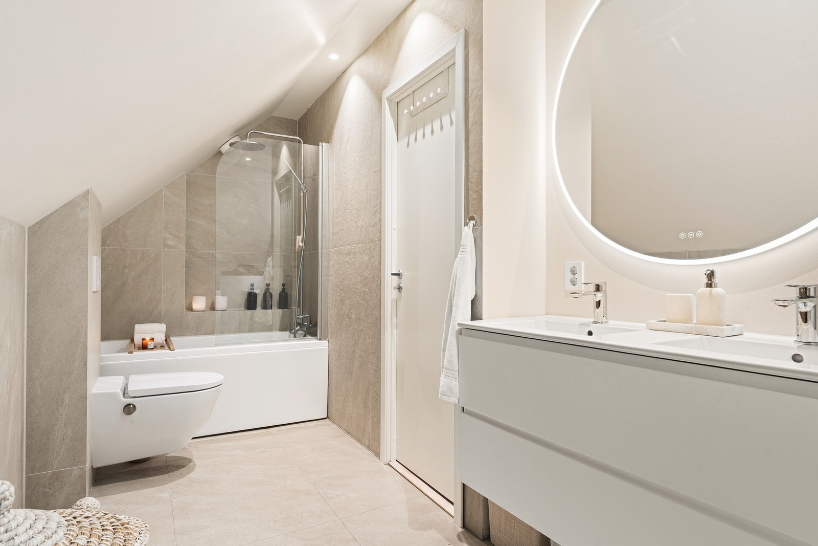 Badet fremstår som meget moderne med store fliser og tidsriktige fargetoner. Galleribilde