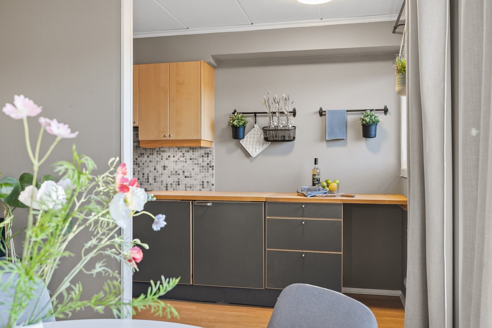 Delvis åpen løsning fra stuen mot kjøkkenet, som skaper en luftig og sosial romfølelse. Denne løsningen gjør det enkelt å både lage mat og delta i samtaler fra stuen, og bidrar til et hjem som er både praktisk i hverdagen og trivelig når man har gjester. Galleribilde