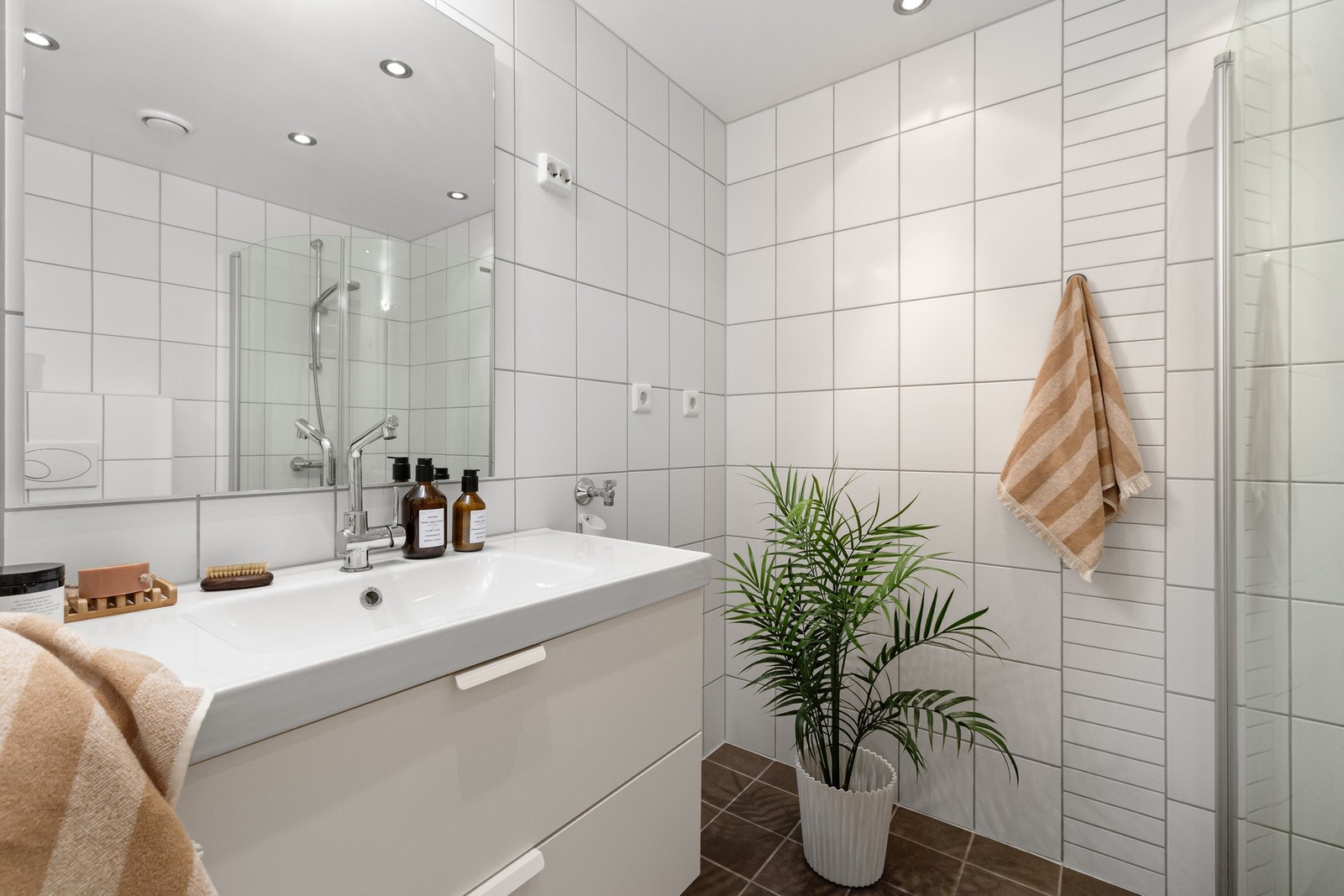 Moderne baderom med behagelige varmekabler, opplegg for vaskemaskin og romslig hjørnedusj. Galleribilde