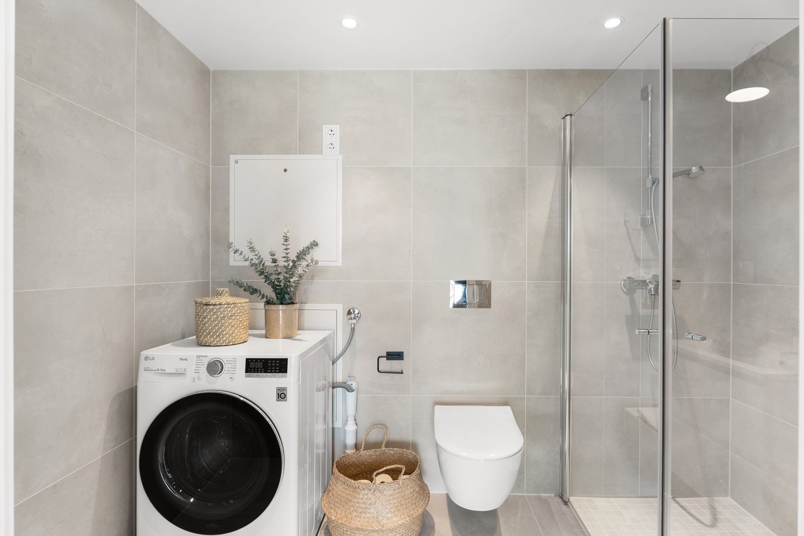 Badet er utstyrt med servantinnredning, dusjhjørne med glassdører og vegghengt toalett. Det er plass og opplegg for vaskemaskin. Galleribilde