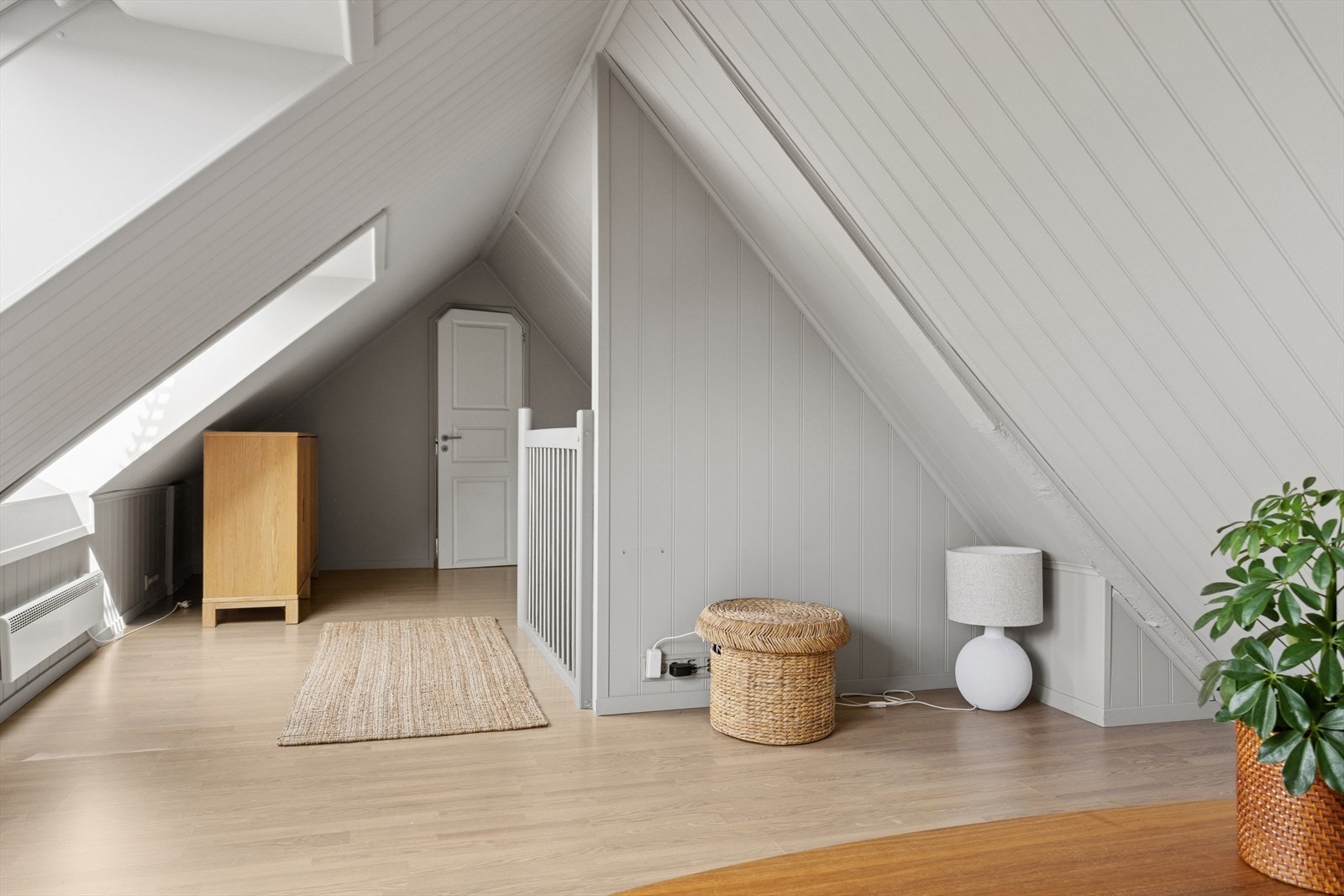 Loftstue og gang med dør til soverom i bakgrunnen. Galleribilde