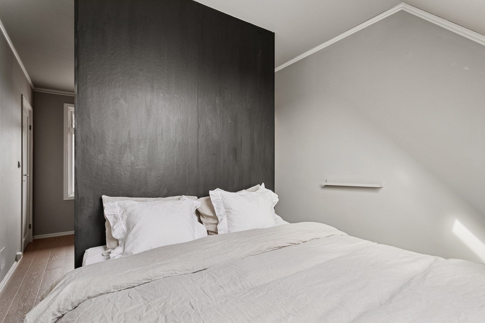 Det største soverommet ligger i den nederste etasjen. Her fungerer garderobeskapene som en romdeler til fordel for kontorplass og en walk-in garderobeløsning. Galleribilde